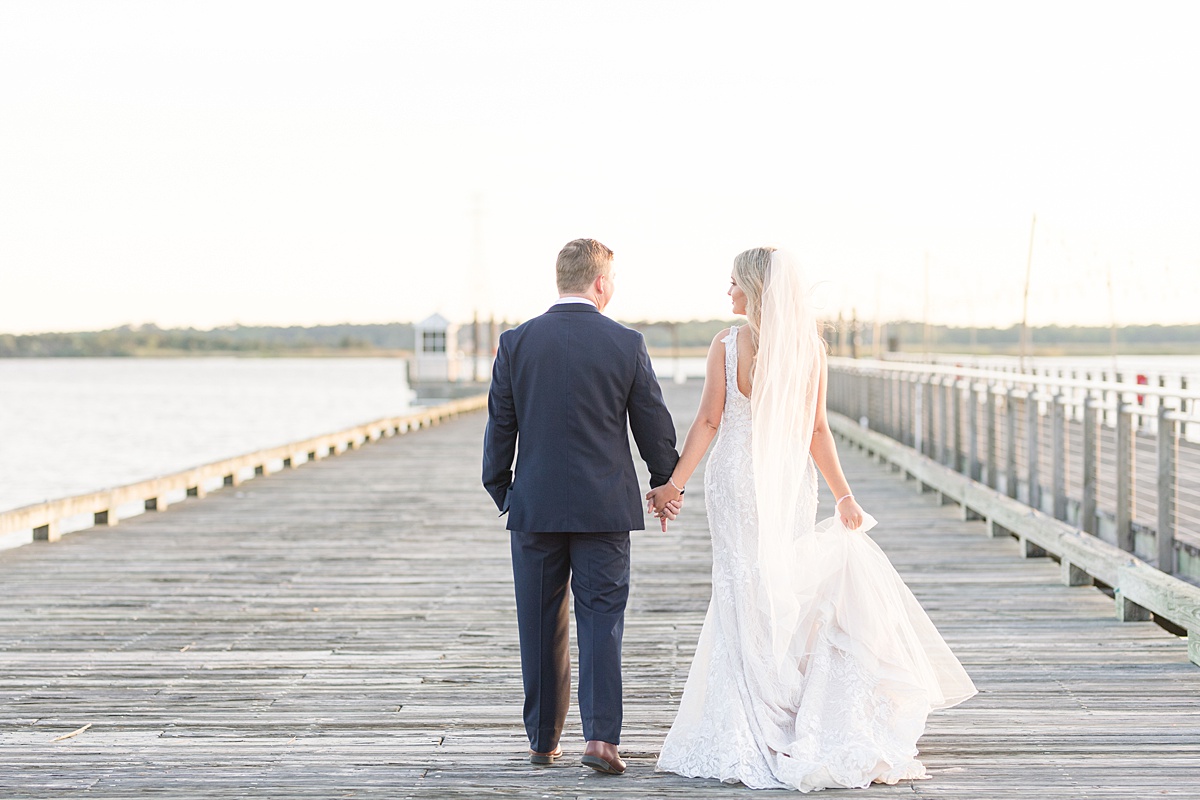 bride and groom walking on pier to water