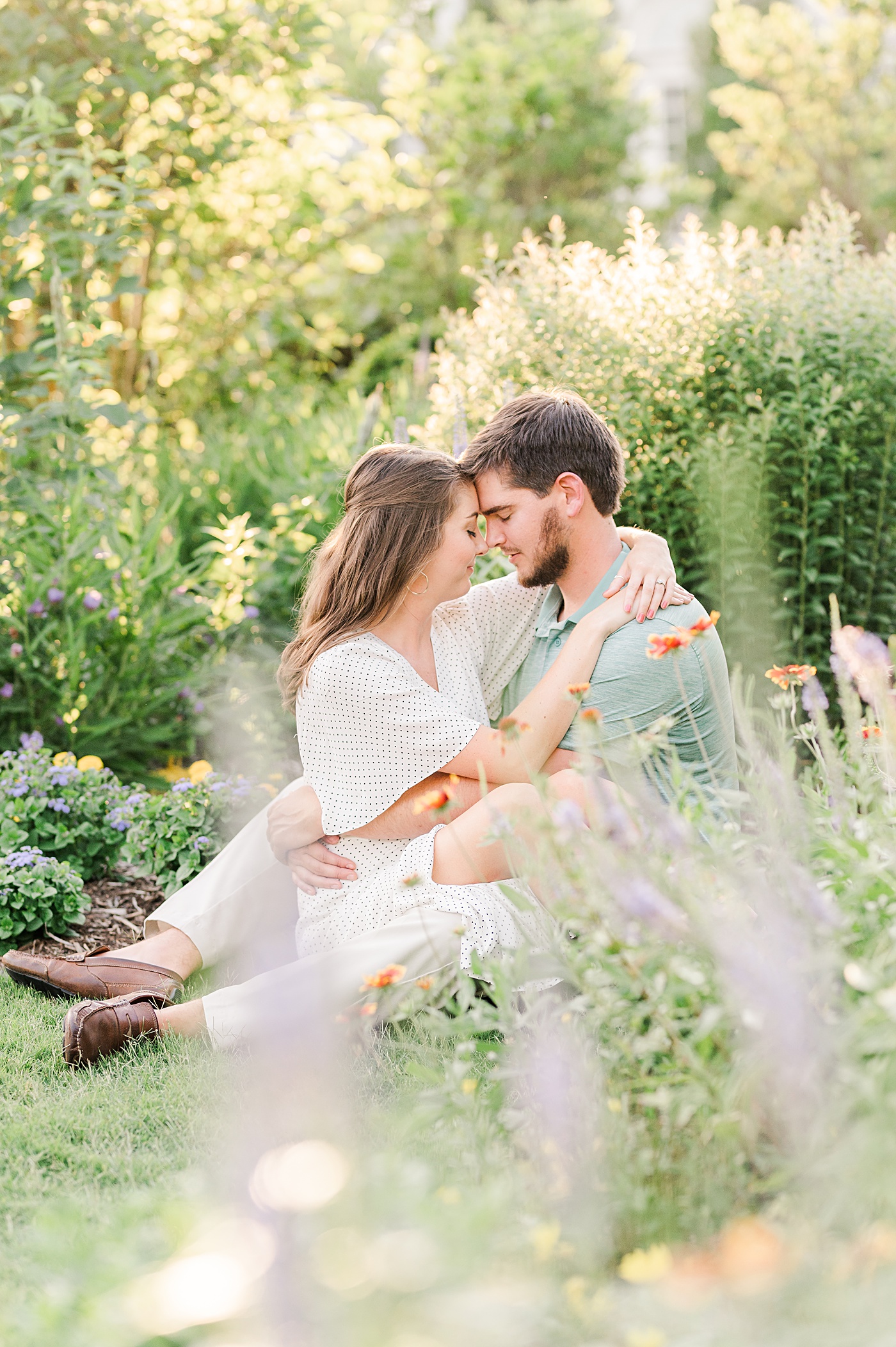 bride and groom setting in reynolda gardens during their engagement session