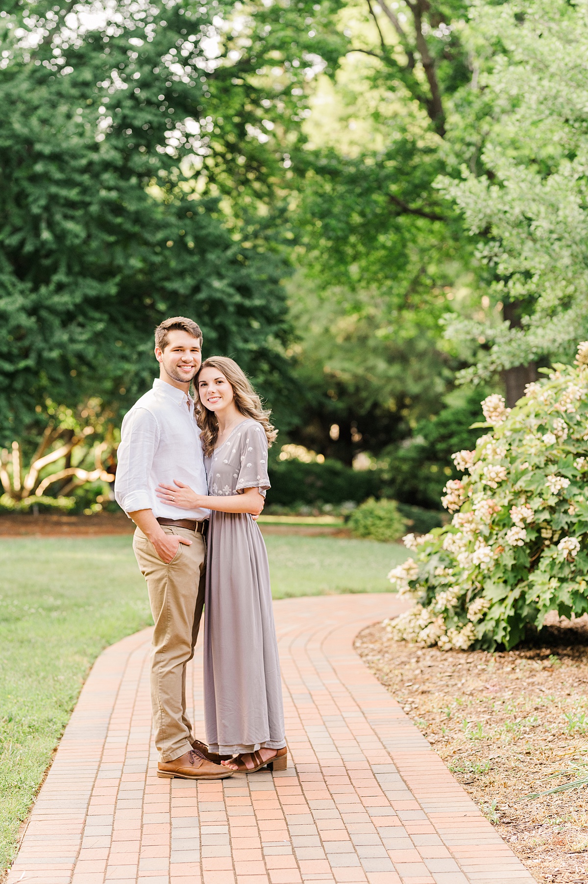 couple posing for engagement session on brick pathway in Clemmons nc