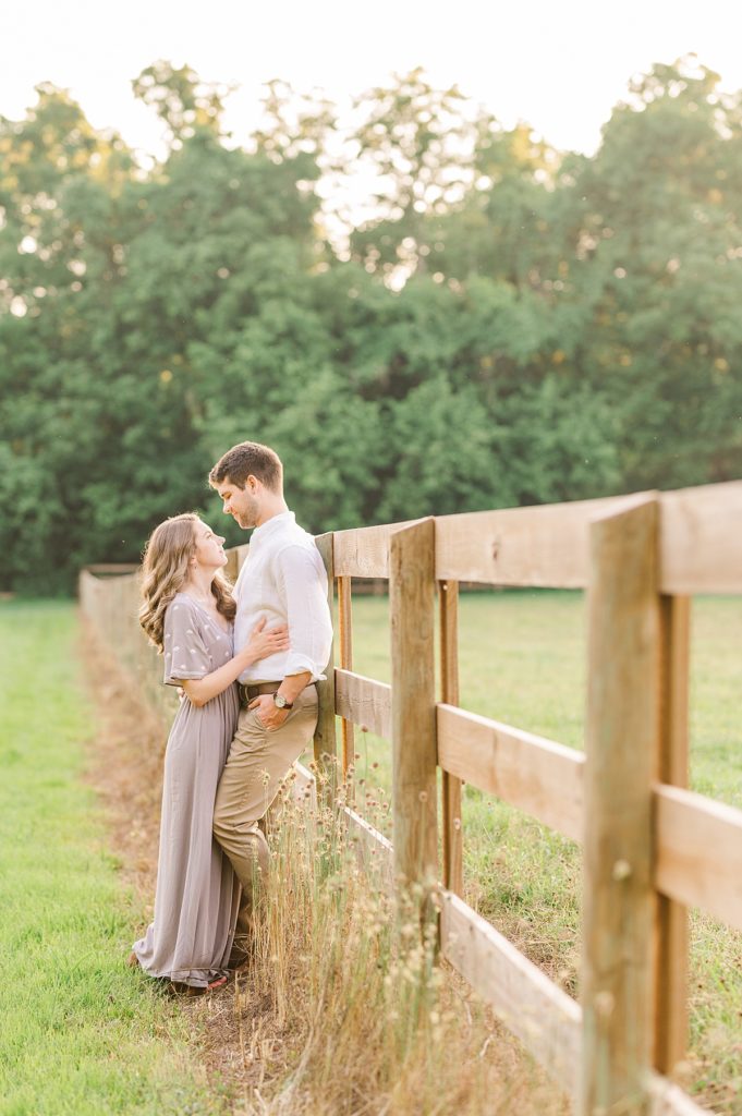 couple sharing a sweet moment against fence line at tanglewood