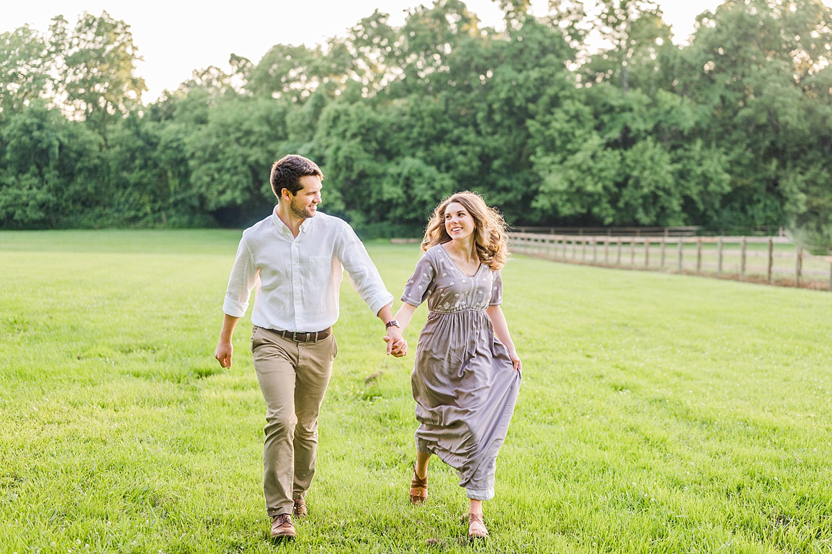 couple running in a field during their engagement session