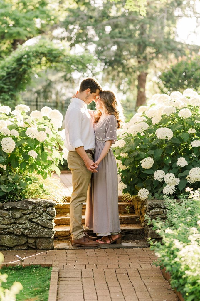 couple touching foreheads in their garden engagement session