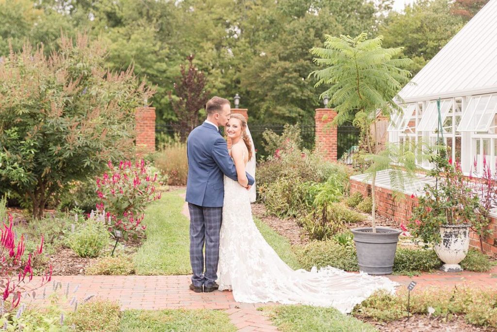 Bride and Groom posing for pictures in the gardens at a Winston Salem wedding venue- Moore's Spring Manor