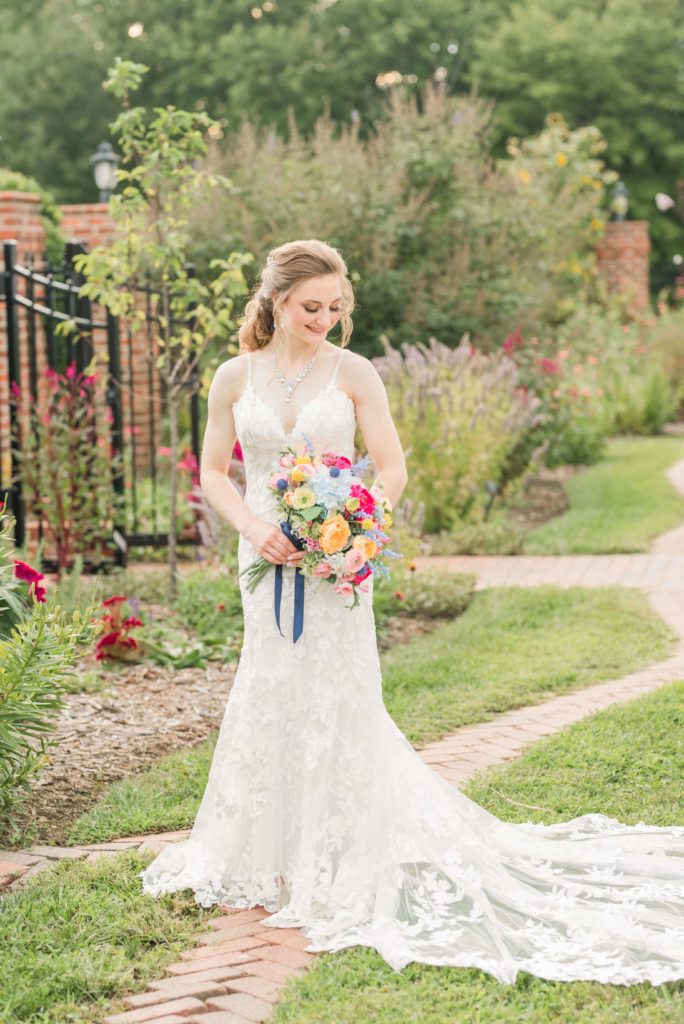 bride standing in gardens holding a bouquet at Moores spring manor