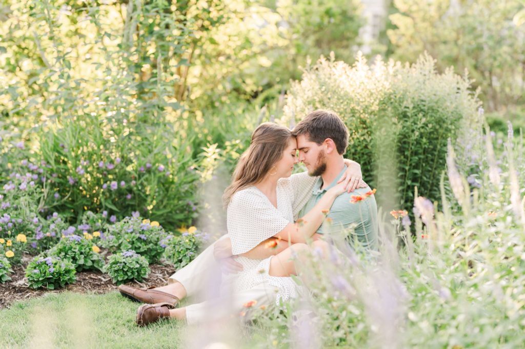 couple sitting in the gardens during their engagement session at reynolda gardens