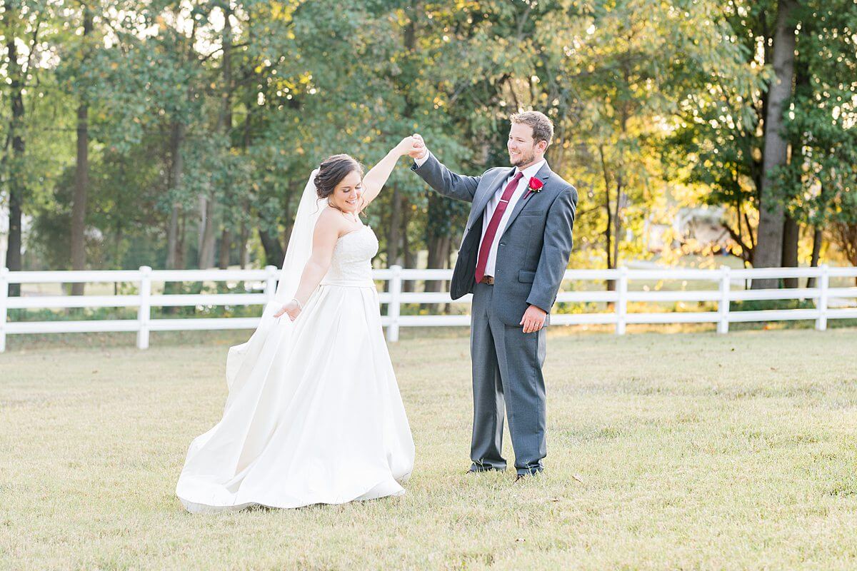 bride and groom dancing in field at legacy stables and events