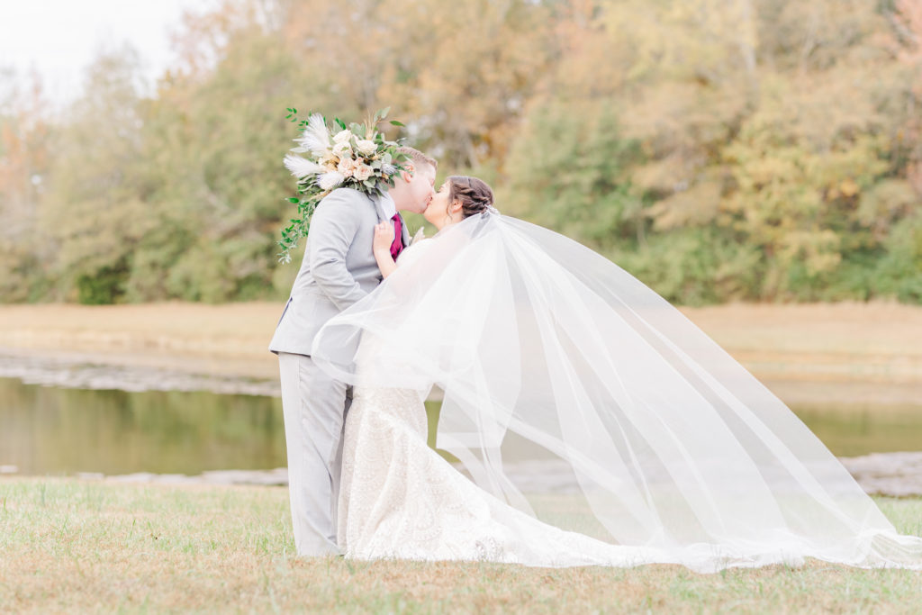 Couple kissing on the lawn at a Duke mansion wedding in the fall
